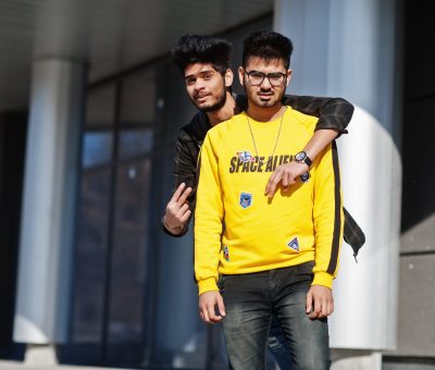 Two asian guys posed against new modern building.